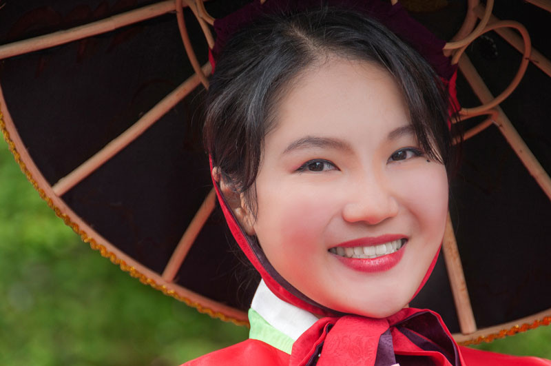 Portrait of young Asian lady wearing a red dress and black hat