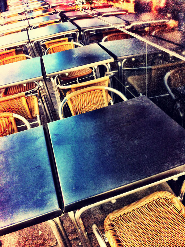 Cafe tables outdoors, with reflection. Grunge look, taken with iPhone