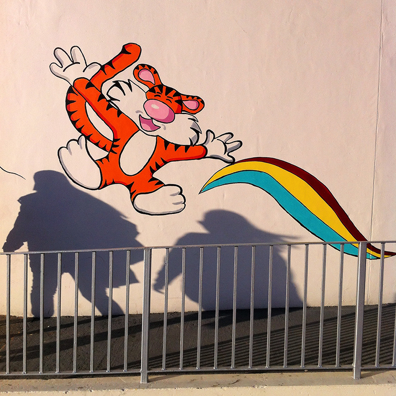 Cartoon tiger on a wall with two people shadows. Fountain Park, Edinburgh. Taken with iPhone.