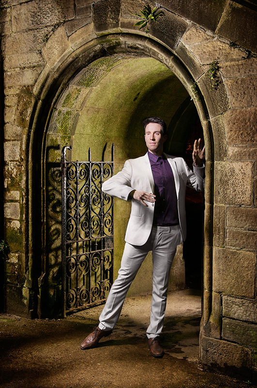 Light painting of male dancer wearing a suit and framed with one arch of McKenzie bridge, in Stockbridge, Edinburgh
