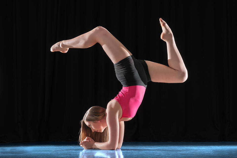 Dancer acrobatics in front of a black background in a dance studio