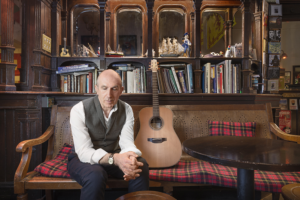 Singer-songwriter Norman Lamont with guitar at the Captain's bar, Edinburgh