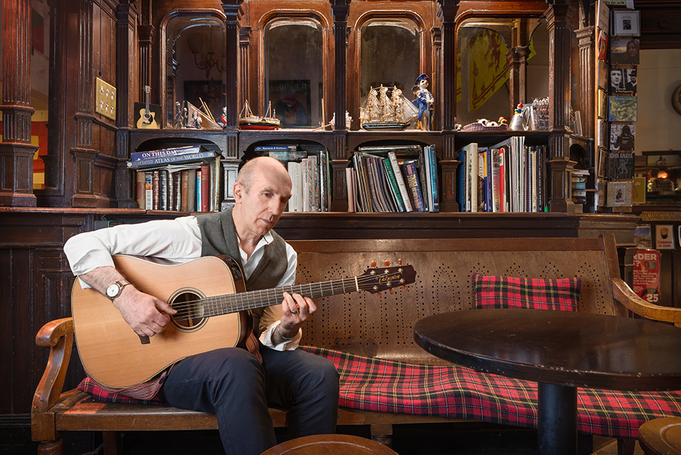 Singer-songwriter Norman Lamont with guitar at the Captain's bar, Edinburgh