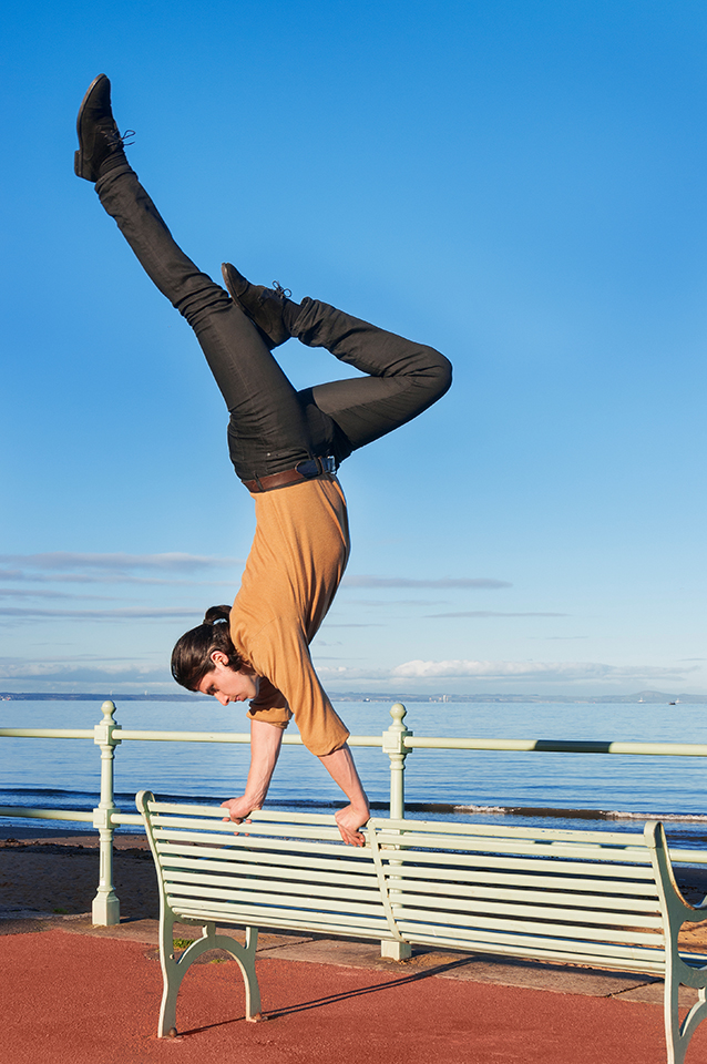 Dancer Paul Distefano doing a hand stand on a bench in Portobello