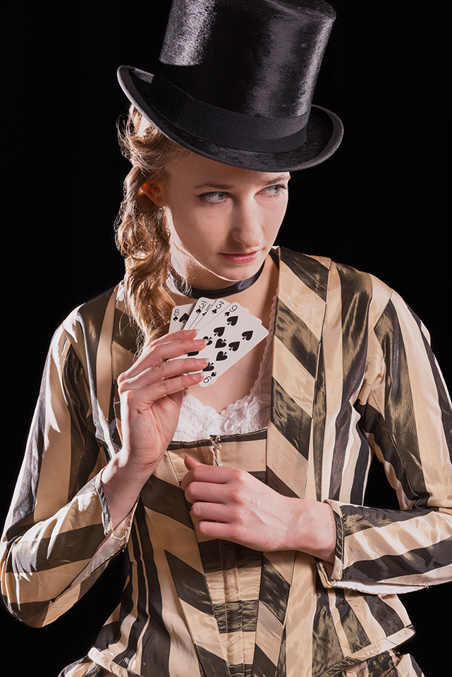 Rosella Elphnstone wearing a vintage dress and holding playing cards