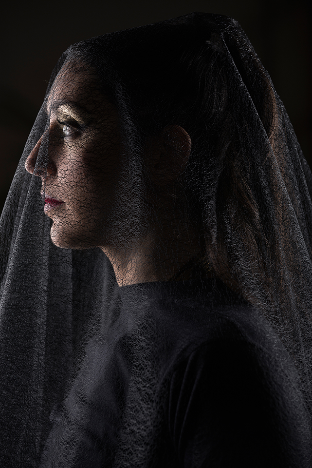 Profile portrait of Zoja Dravia with a black veil on her face