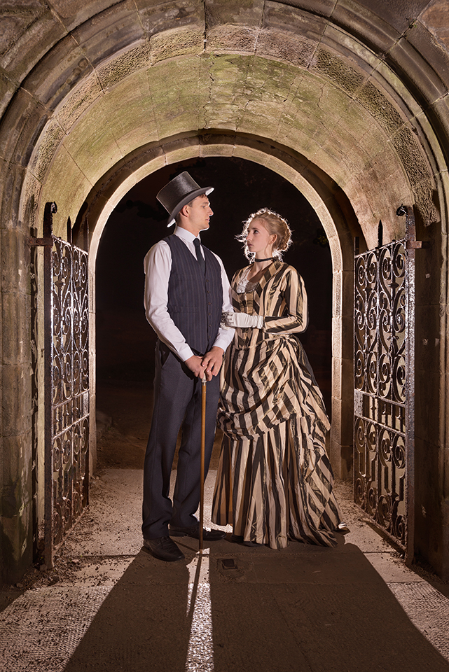 Rosella Elphinstone and Luke Aquilina in vintage clothing under an arch
