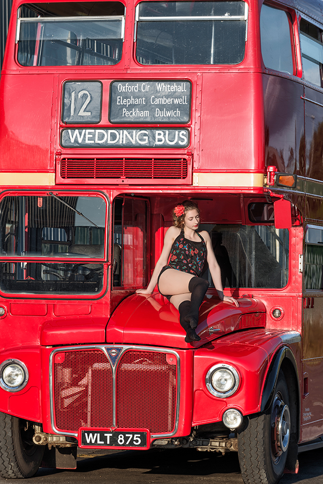 Circus artist Rosella Elphinstone on the bonnet (hood) of a vintage double-decker bus