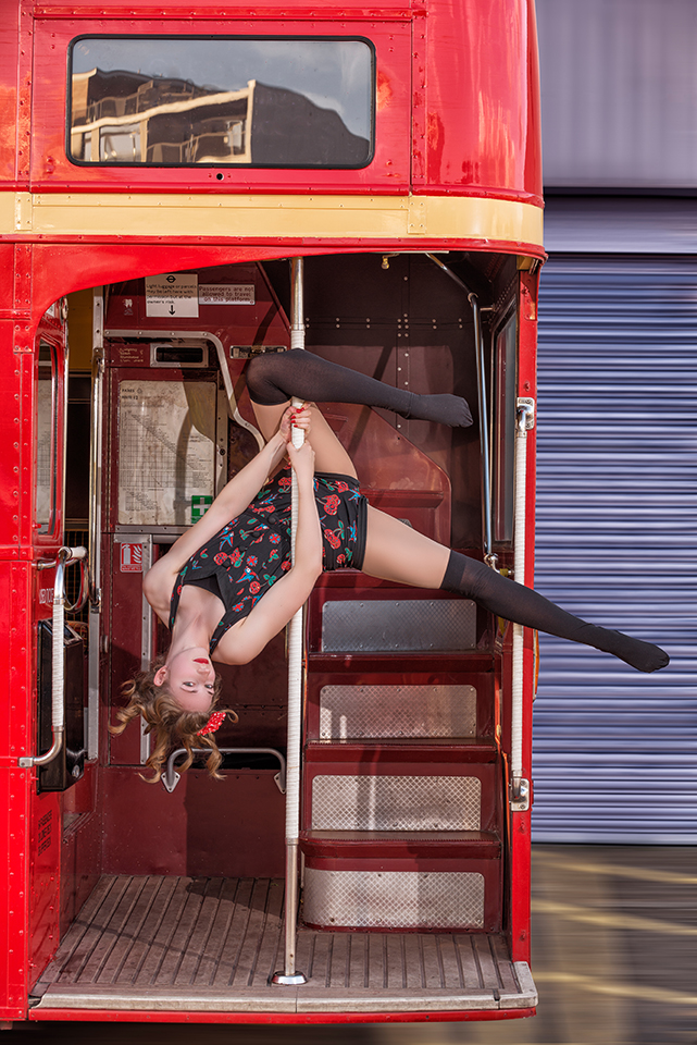 Circus artist Rosella Elphinstone doing some acrobatics at the back of a vintage double-decker bus