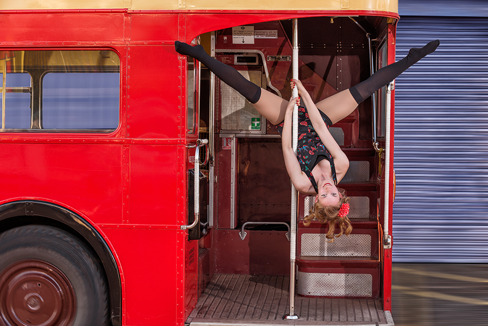 Circus artist Rosella Elphinstone doing some acrobatics at the back of a vintage double-decker bus