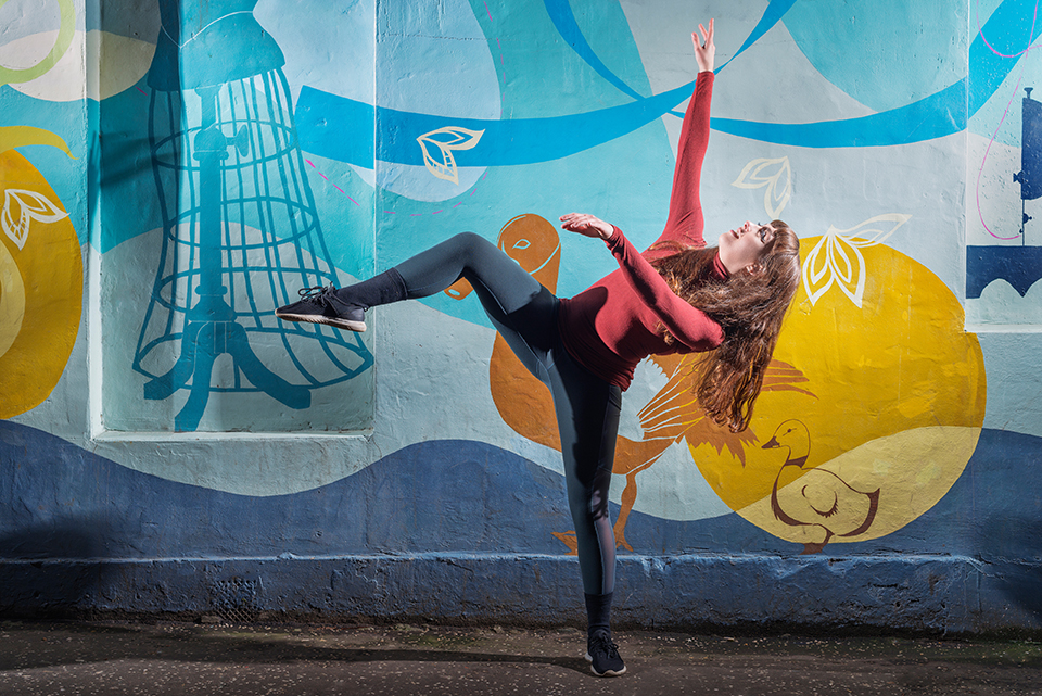 Dancer Jorja Follina in front of a graffiti covered wall
