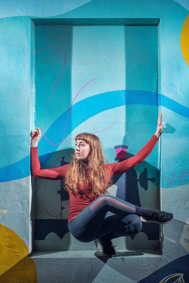 Dancer Jorja Follina in front of a graffiti covered wall