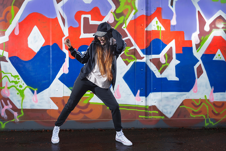 Hip Hop dancer Savitha Devi in front of graffiti mural