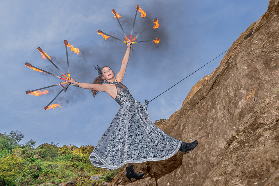 Circus artist Zoja Dravai rappelling with fire