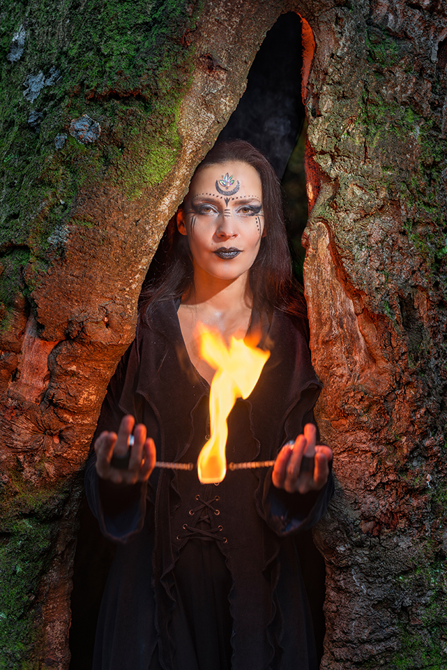 Justina Hermann in a hollow tree handling fire