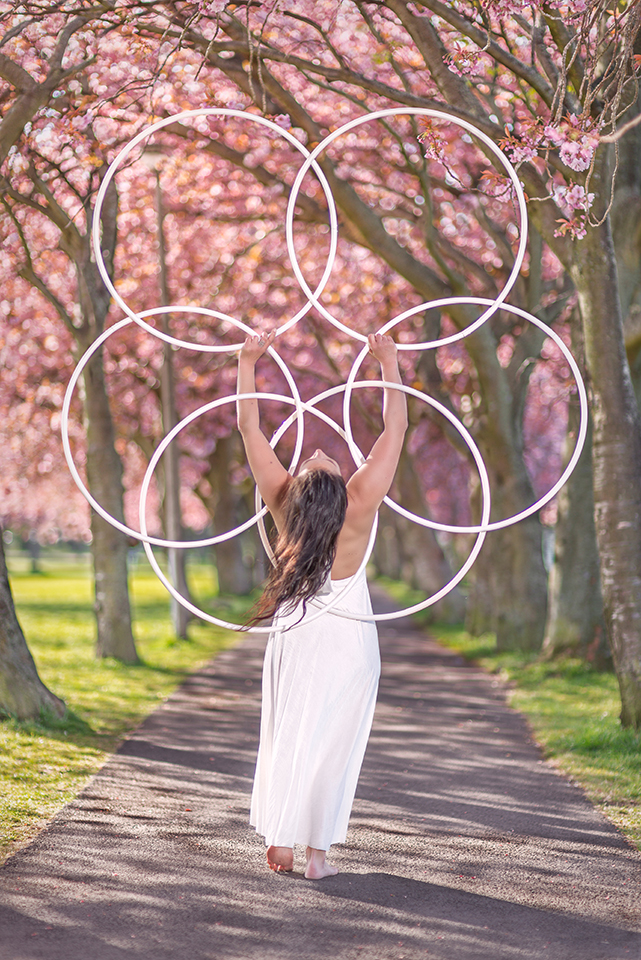 Jusztina Hermann balancing hoops under the cherry blossoms