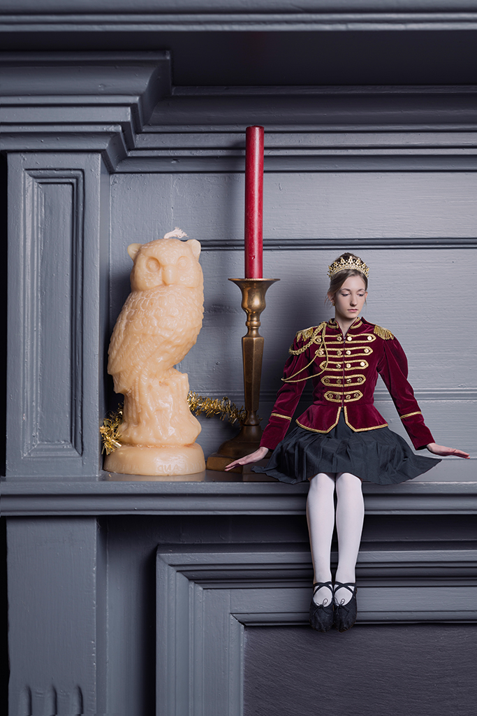 Photomontage of a young lady in a Nutcracker doll outfit on a fireplace mantle