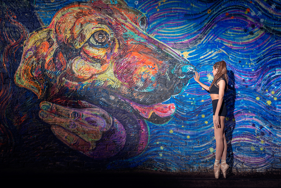 Nicole Reid interacting with a large painted dog on the Colinton Tunnel wall