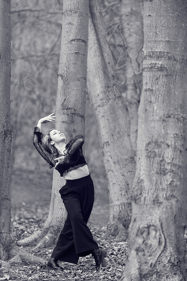Stefi Chertsova doing a dance pose in the forest of Blackford Hill