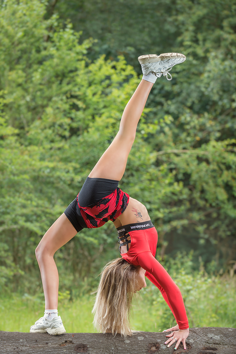 Dancer Holly Wilson on a fallen tree showing her athleticism.