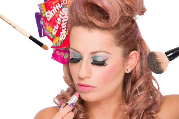 Beauty model with candy girl themed hair, makeup and nail with lipstick and makeup brushes,.
