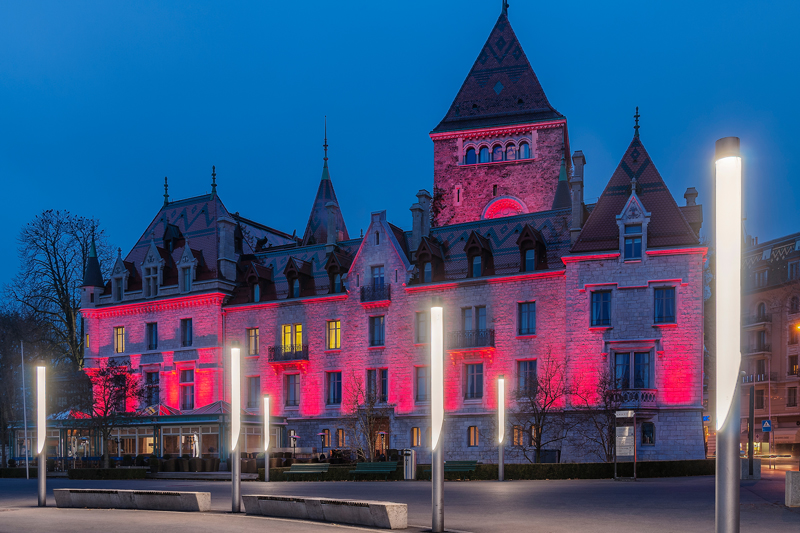 Ouchy Castle Hotel in Lausanne Switzerland, night photograph with the Castle illuminated in red.