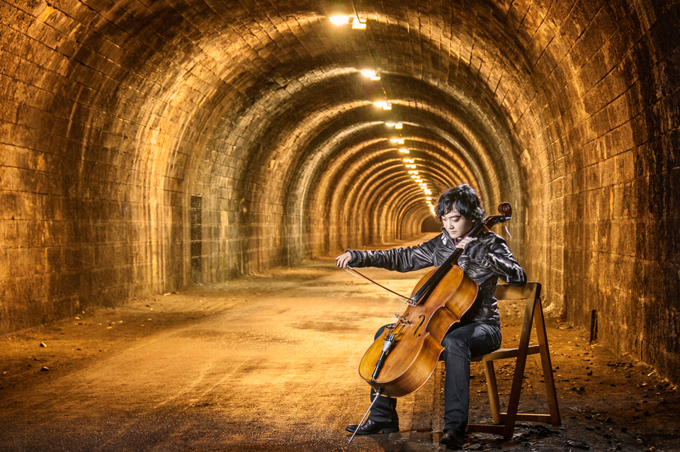 Composer Atzi playing the cello inside the Innocent Railway tunnel in Edinburgh