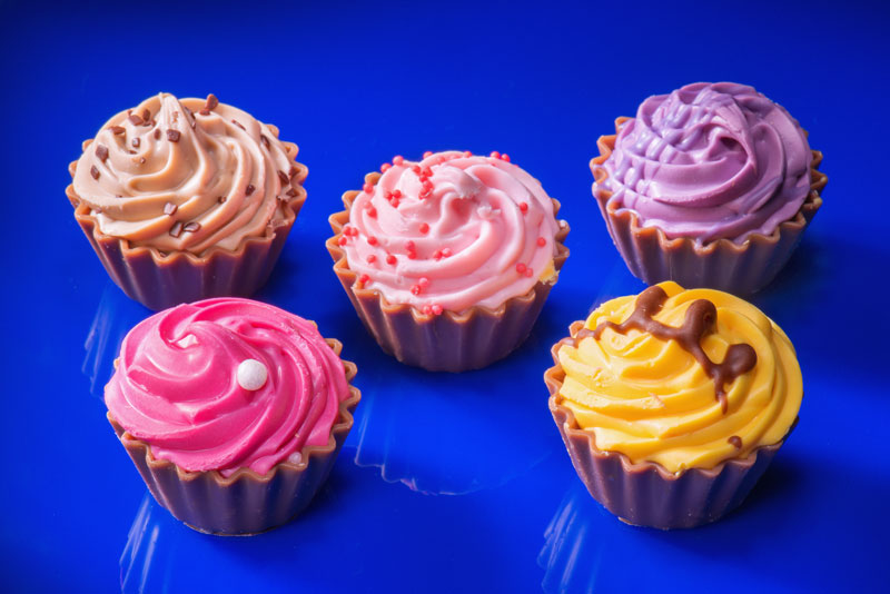 Light painting of colourful cupcakes on blue plexiglas