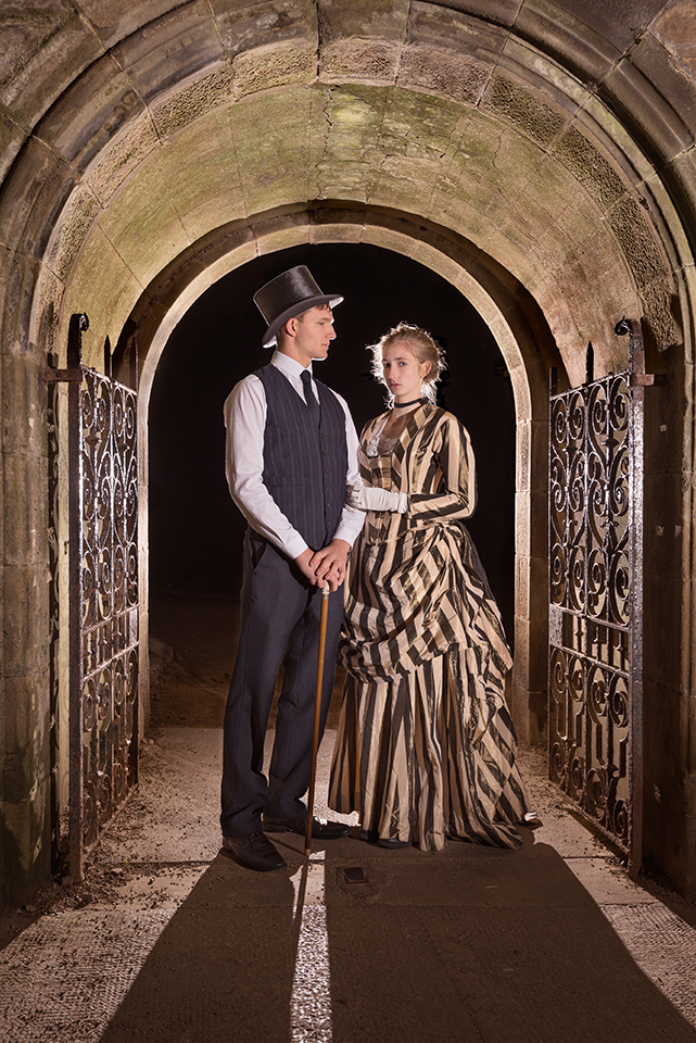Rosella Elphinstone and Luke Aquilina in vintage clothing under an arch