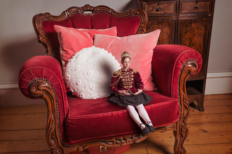 Photomontage of a young lady in a Nutcracker doll outfit on an armchchair