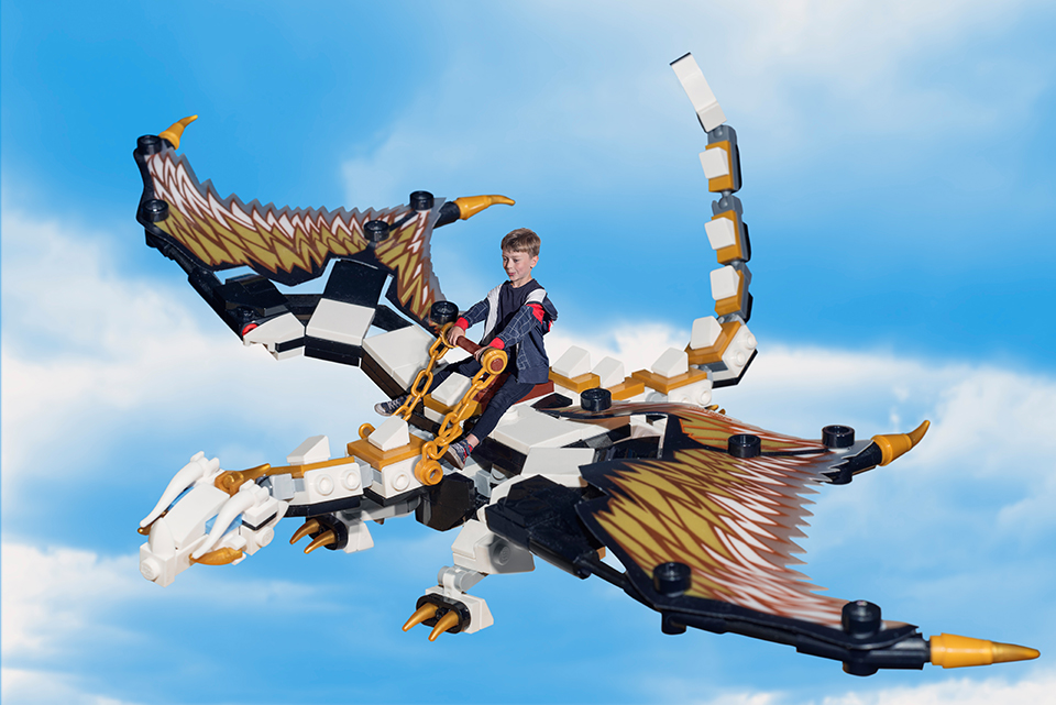 Final composite of boy riding his toy Lego dragon