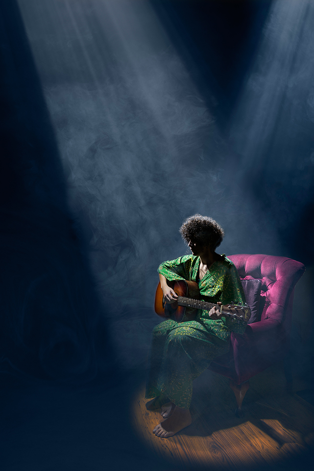 Light painting of singer/songwriter Ilaria Rucco in a chair, lit mostly from behind